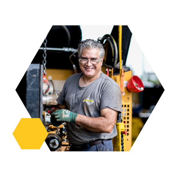 technician with grey hair and glasses smiling as he works